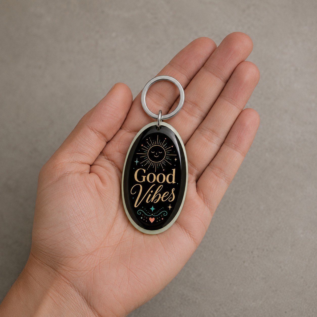 Porte-clés Good Vibes tenu dans une main, échelle réelle