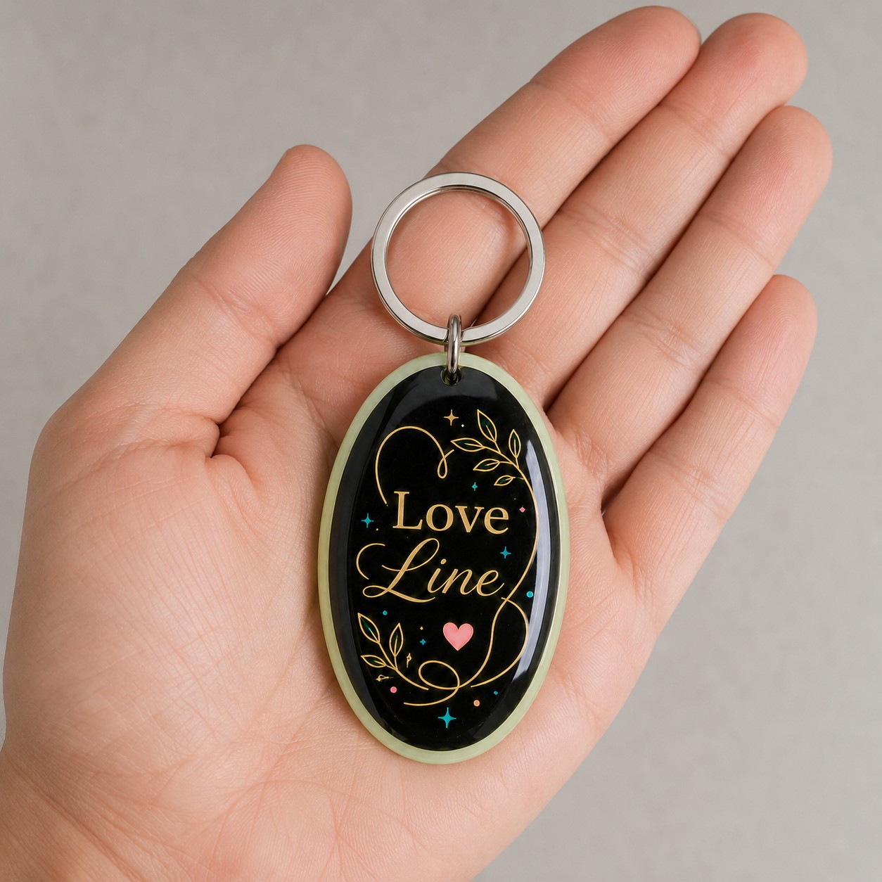Porte-clés Love Line tenu dans une main, échelle réelle