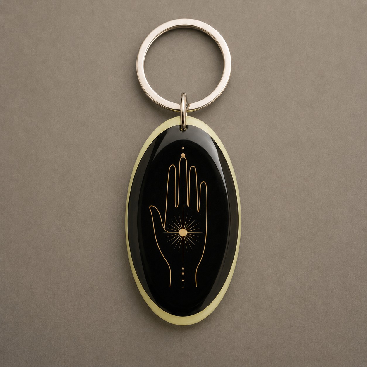 Main de Lumière, main symbolique stylisée, des lignes dorées et des détails lumineux, porte-clés photoluminescent en lumière naturelle