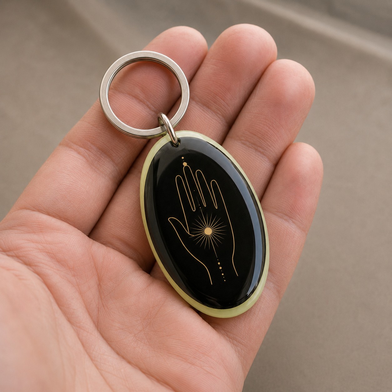 Porte-clés Main de Lumière tenu dans une main, échelle réelle